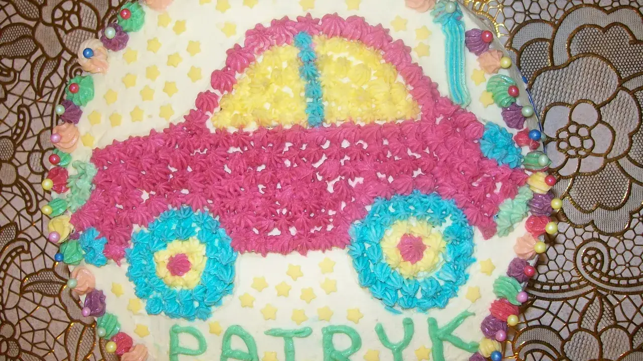 Kolorowy tort w kształcie samochodu z imieniem Patryk.
