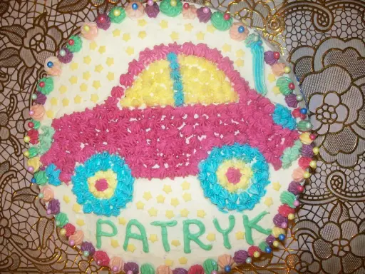 Kolorowy tort w kształcie samochodu z imieniem Patryk.
