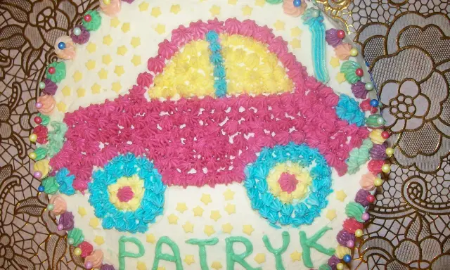 Kolorowy tort w kształcie samochodu z imieniem Patryk.