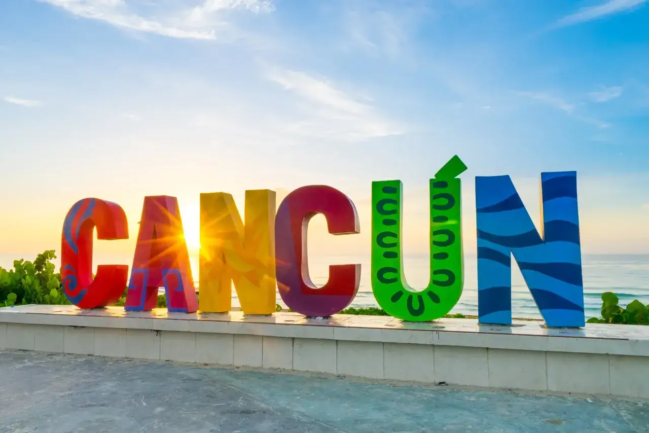 Kalendarz pogody Cancun z ikonami słońca i deszczu